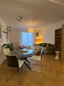 sala de estar con mesa de cristal y sillas en Spacieux logement au pied du Vercors, en Saint-Jean-en-Royans