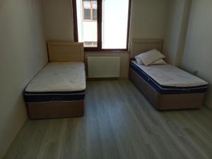 two beds in a small room with two windows at Pelittepe sitesi in Pelitli