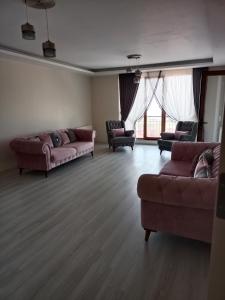 ein Wohnzimmer mit 2 Sofas und 2 Stühlen in der Unterkunft Pelittepe sitesi in Pelitli