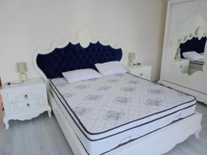 a white bedroom with a blue and white bed and two night stands at Pelittepe sitesi in Pelitli