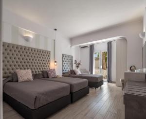 un soggiorno con un letto e un divano di Daedalus Hotel a Firà