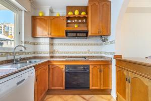 a kitchen with wooden cabinets and a sink at Mar Báltico in Torrevieja