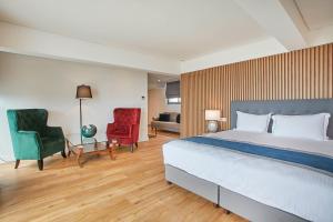 a bedroom with a large bed and two chairs at Glyfada Riviera Hotel in Athens