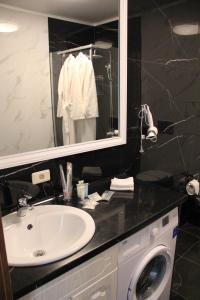 a bathroom with a sink and a washing machine at Golden Park Hotel in Pavlodar