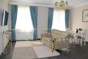 a living room with a couch and a table at Golden Park Hotel in Pavlodar