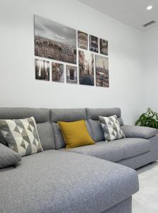 eine Couch in einem Wohnzimmer mit Bildern an der Wand in der Unterkunft Varese Apartment in Varese