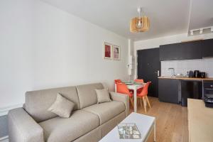 sala de estar con sofá y cocina en Residence Boulogne Centre le passage by Studio prestige en Boulogne-Billancourt
