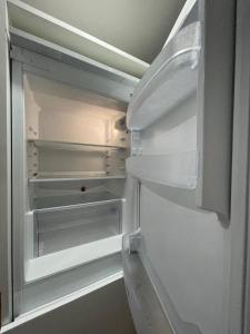 an empty refrigerator with its door open with the door open at The Michigan Towers Boutique in Manchester