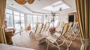 a room with chairs and a table and windows at Hotel Guesthouse Dalnig in Bad Kleinkirchheim