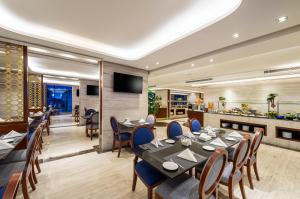 a restaurant with tables and chairs and a kitchen at Blue Diamond Hotel in Jeddah