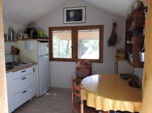 una cocina con mesa y ventana. en Cabane sous les Chênes, en Montagnac