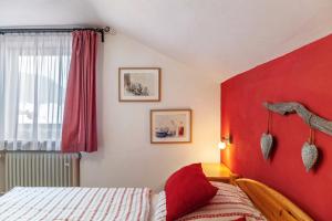sypialnia z czerwonym zagłówkiem i łóżkiem w obiekcie Barbara Jais w mieście Mittenwald