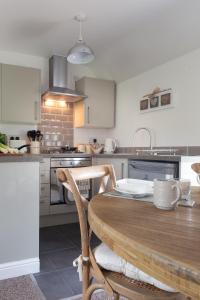 a kitchen with a wooden table and a kitchen counters at First floor flat with parking in Wheatley