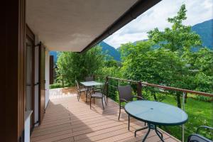 un balcón con mesas y sillas y montañas en el fondo en House Jelenko en Bovec