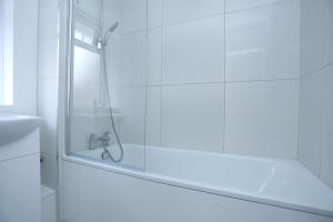 a glass shower in a bathroom with a sink at Abbeywood Station House London in London +23 photos