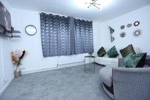 a living room with a couch and a window at Abbeywood Station House London in London