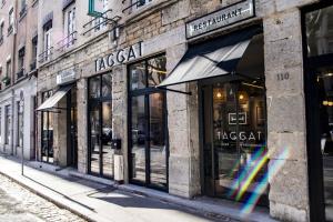 una fila de tiendas en una calle con un arco iris en Hôtel Taggât, en Lyon