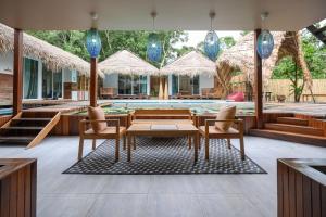 an outdoor dining area with tables and chairs and a pool at Varni Homestay in Phatthalung