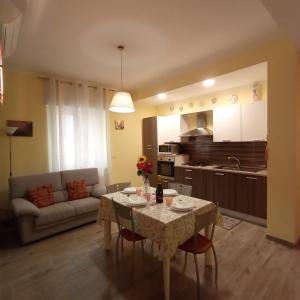 cocina y sala de estar con mesa y sofá en Piazza Mazzini 21, en Loano