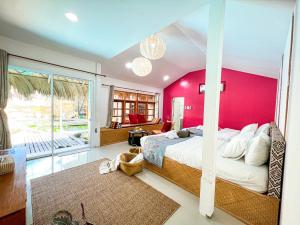 a bedroom with a pink accent wall and a bed at Varni Homestay in Phatthalung