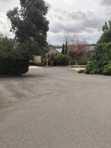 an empty parking lot with a tree and a house at Hepburn Hideaway Villa ~ Hepburn / Daylesford in Hepburn Springs