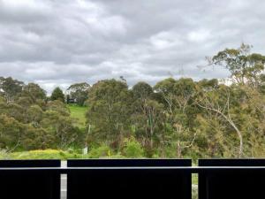 a view of a field and trees from a balcony at Hepburn Hideaway Villa ~ Hepburn / Daylesford in Hepburn Springs