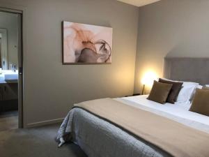 a bedroom with a large bed and a bathroom at Hepburn Hideaway Villa ~ Hepburn / Daylesford in Hepburn Springs