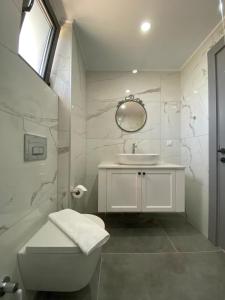 a white bathroom with a sink and a toilet at Hemera Suite in Kas