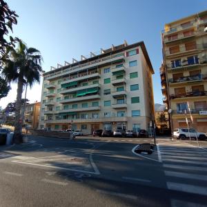 a tall building with cars parked in front of a street at Piazza Mazzini 21 in Loano