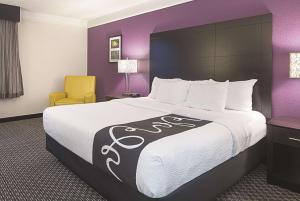 a hotel room with a large bed and a chair at La Quinta by Wyndham Las Vegas Summerlin Tech in Las Vegas