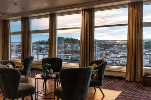 una sala de espera con sillas y ventanas grandes en Scandic Kristiansund en Kristiansund