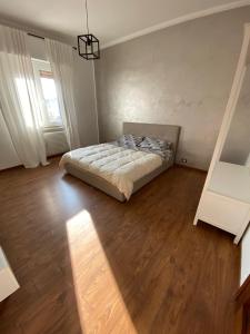 Schlafzimmer mit einem Bett und Holzboden in der Unterkunft Hlux OI ₐffᵢₜₜₐCₐₘₑᵣₑ in Piacenza