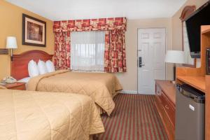 Cette chambre comprend deux lits et une télévision. dans l'établissement Travelodge by Wyndham Klamath Falls, à Klamath Falls