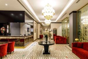 a lobby of a hotel with red chairs and a table at Ramada by Wyndham Istanbul Golden Horn in Istanbul