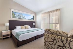 um quarto com uma cama grande e uma janela em Quality Hotel Point Cook em Point Cook