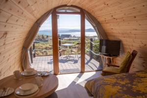 Habitación con cama, TV y ventana. en Arranmore Glamping, en Aphort