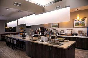 a kitchen with a large counter with dishes on it at StoneHill Lawrence, Trademark Collection by Wyndham in Lawrence