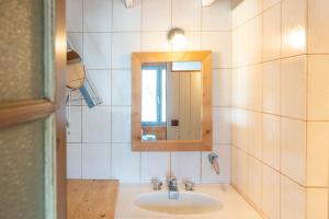 ein Bad mit einem Waschbecken und einem Spiegel in der Unterkunft La Petite Maison De Papaye in Le Palais