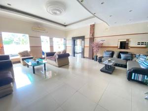 a large living room with couches and tables at Lilianto Hotel Polewali Mitra RedDoorz in Campalagiang