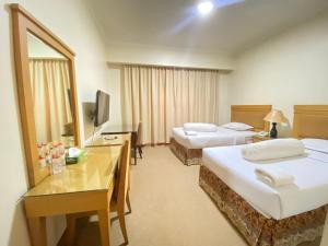 a hotel room with two beds and a mirror at Lilianto Hotel Polewali Mitra RedDoorz in Campalagiang