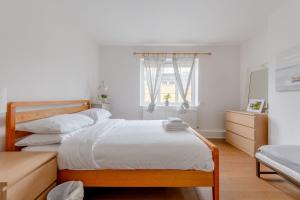 a bedroom with two beds and a window at Stylish and Central 1 Bedroom Flat in Maida Vale in London