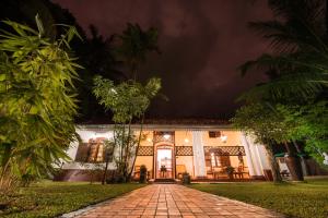 a house at night with a cobblestone driveway at Fortress de Jayaweera - Historic Villa - A proud legacy since 1889 in Bentota