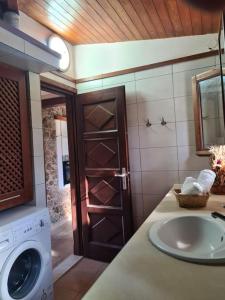 łazienka z umywalką i pralką w obiekcie Annas cozy cottage Kalymnos w mieście Kalimnos +25 zdjęć