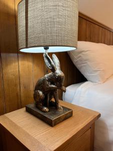 a statue of a rabbit on a table with a lamp at The Forester in Shaftesbury