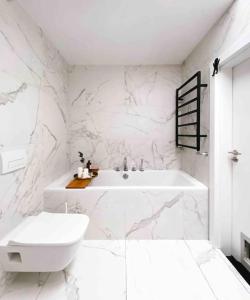 een witte badkamer met een bad en een wastafel bij Apartament Loft 80m2 w sercu miasta in Bydgoszcz