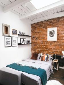 een bed in een kamer met een bakstenen muur bij Apartament Loft 80m2 w sercu miasta in Bydgoszcz