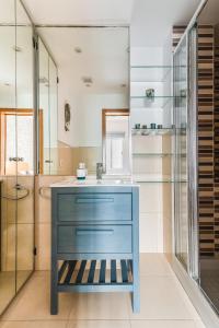 ein Badezimmer mit einem blauen Waschbecken und einem Spiegel in der Unterkunft Home2Book El Perenquén Las Canteras in Las Palmas de Gran Canaria