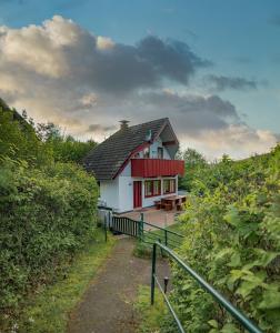 una casa roja y blanca con un camino que conduce a ella en Ferienhaus 100 am See im Bergland, en Kirchheim