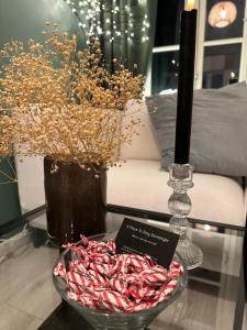 a table with a bowl of candy canes and a vase at A Place To Stay Stavanger, apartment 3 in Stavanger