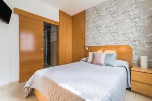 ein Schlafzimmer mit einem Bett und einer Wand mit Blumen in der Unterkunft Home2Book El Perenquén Las Canteras in Las Palmas de Gran Canaria